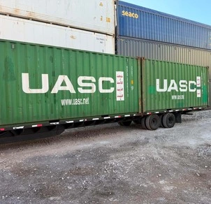 green storage containers loaded on a trailer